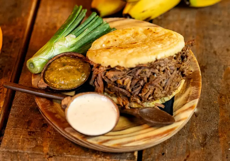Arepa de carne mechada con salsas